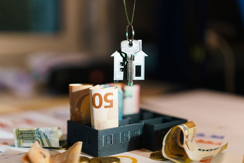 House key resting on euro banknotes representing estate and property value