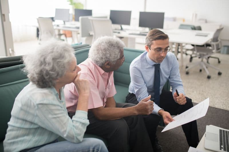 Financial adviser consulting with elderly clients